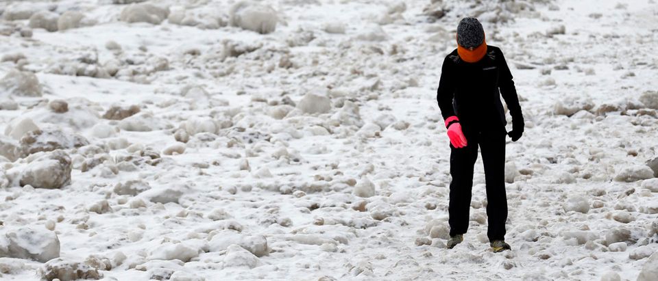 A woman walks between chunks of ice along Lake Michigan in Chicago, Illinois, February 17, 2015. A deadly winter storm paralysed much of the eastern United States on Tuesday, snarling travel and shutting down federal offices in Washington, and forecasters warned of the worst cold in two decades from another arctic front this week. REUTERS/Jim Young