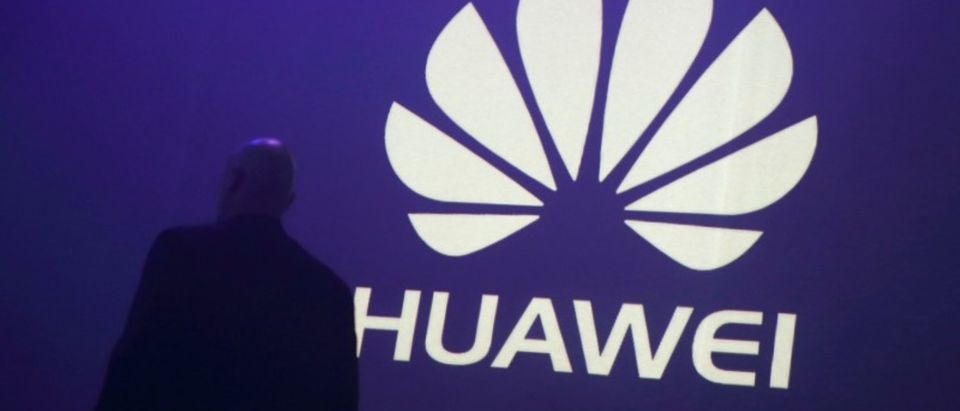 FILE PHOTO - A man walks past a logo during the presentation the Huawei's new smartphone, the Ascend P7, launched by China's Huawei Technologies in Paris