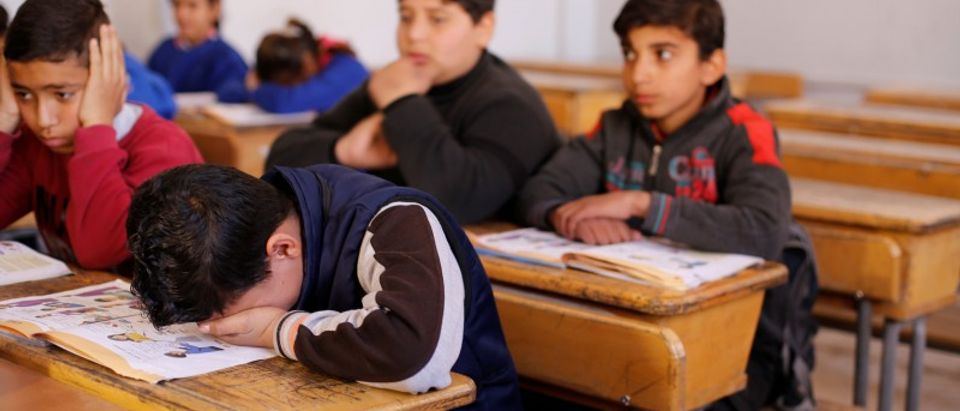 Hussein al-Khalaf, 13, reacts as he sits in a classroom at a school in Sahnaya