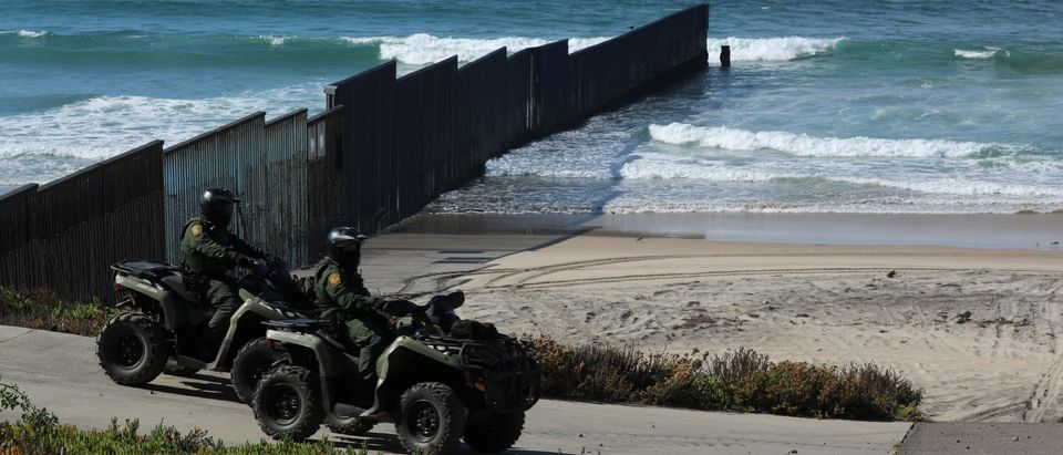 U.S. Customs and Border patrol agents on all-terrain vehicles look over over the Mexico-U.S. border wall where it enters the Pacific Ocean at Border Field State Park in San Diego, California, November 18, 2017. REUTERS/Mike Blake