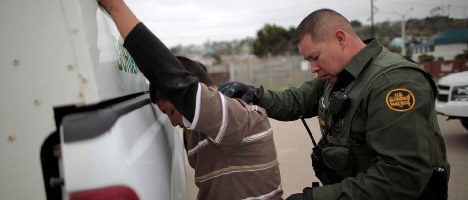 A United States border patrol agent catches an illegal immigrant crossing from Mexico to the U.S. in San Ysidro, California, April 13, 2011. REUTERS/Lucy Nicholson