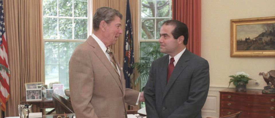 File photo of U.S. President Ronald Reagan speaking with Supreme Court Justice nominee Antonin Scalia in the White House Oval Office