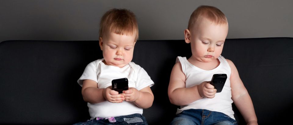 Little babies playing with cellphones and going on social media. [Shutterstock - AlohaHawaii]