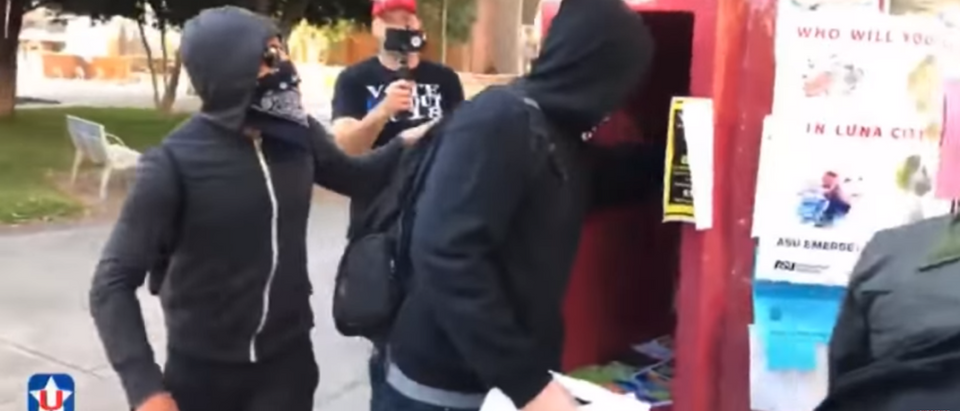 Antifa rips down fliers at Arizona State University honoring individuals slain by illegal aliens. (Photo Credit: YouTube/UNITE AMERICA FIRST)