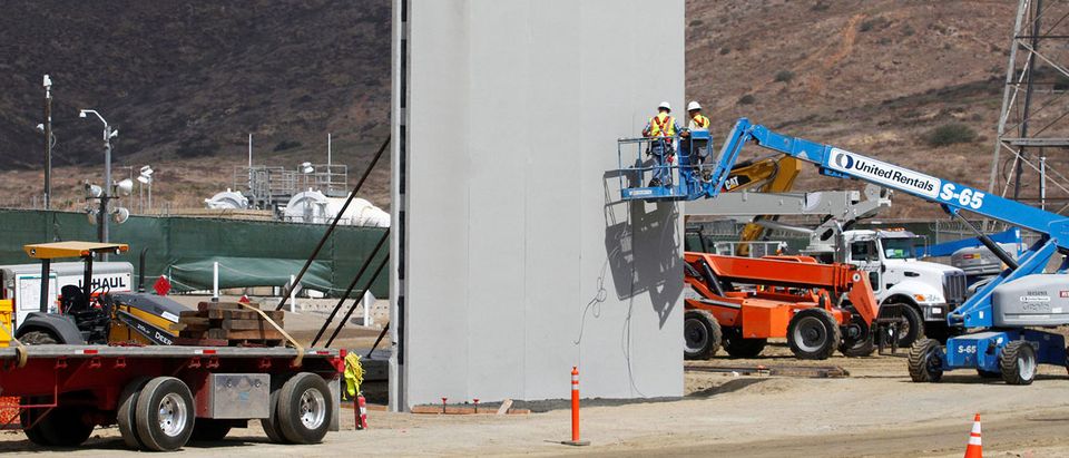 People work in San Diego, California, U.S., at the construction site of prototypes for U.S. President Donald Trump's border wall with Mexico, in this picture taken from the Mexican side of the border in Tijuana, Mexico