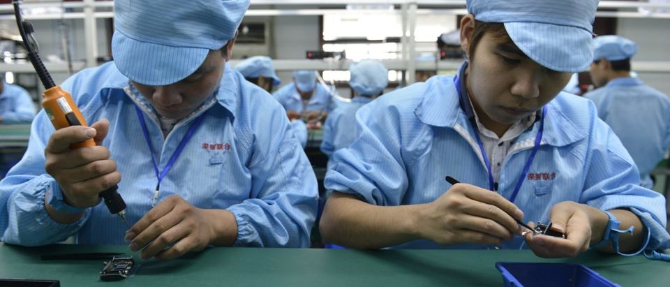 This picture taken on April 22, 2015 shows Chinese workers assembling a cheaper local alternative to the Apple Watch in a factory producing thousands every day in Shenzhen, in southern China's Guangdong province. The much-hyped Apple Watch goes on sale on April 24, but Chinese factories are already churning out cheaper alternatives to the apparent delight of local consumers. (Photo: STR/AFP/Getty Images)