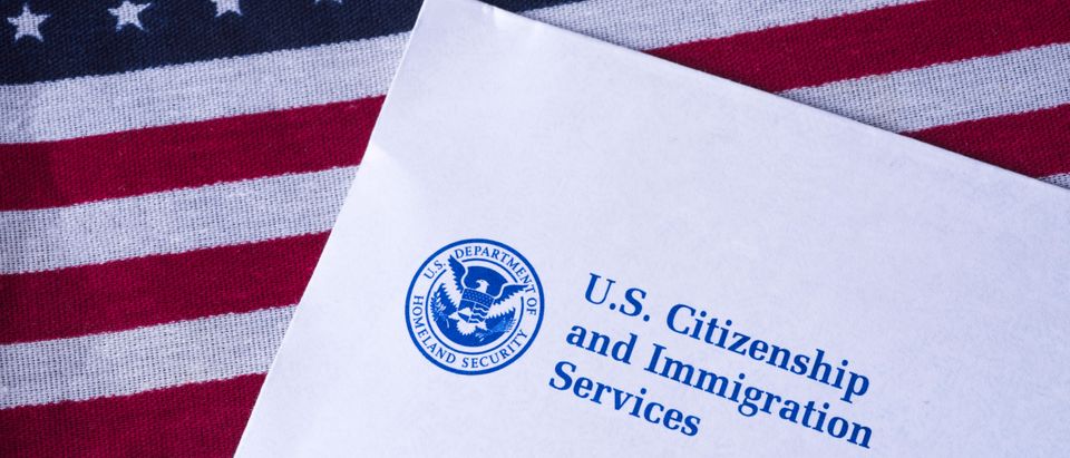 Letter from US Citizenship and Immigration Services on Flag of United States of America. Shutterstock.