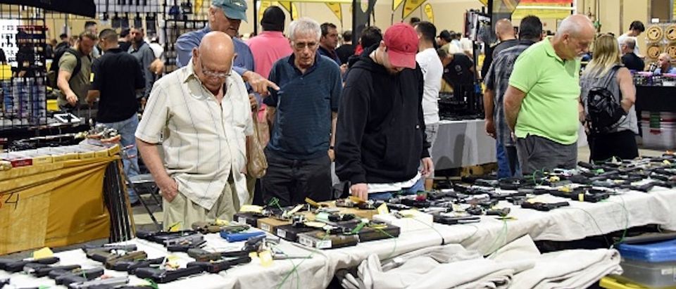 Gun enthusiasts attend the South Florida Gun Show at Dade County Youth Fairgrounds in Miami, Florida, on February 17, 2018. The gun show started three days after a mass shooting 30 miles (48kms) away at the Marjory Douglas High School in Parkland, Florida. Vendors said they were expecting a big turnout and sales, and because of the shooting there will be a panic regarding gun restrictions and new laws that could be put in place. Vendor Domingo Martin said he brought his entire stock of of 42 AR-15's, adding that he is not the only one selling the unit at the weekend show. / AFP PHOTO / Michele Eve Sandberg