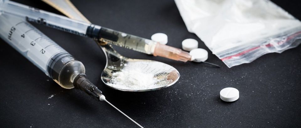 Mother Charged For Drug Death Of Daughter | Drug syringe and cooked heroin on spoon. (FabrikaSimf/Shutterstock)