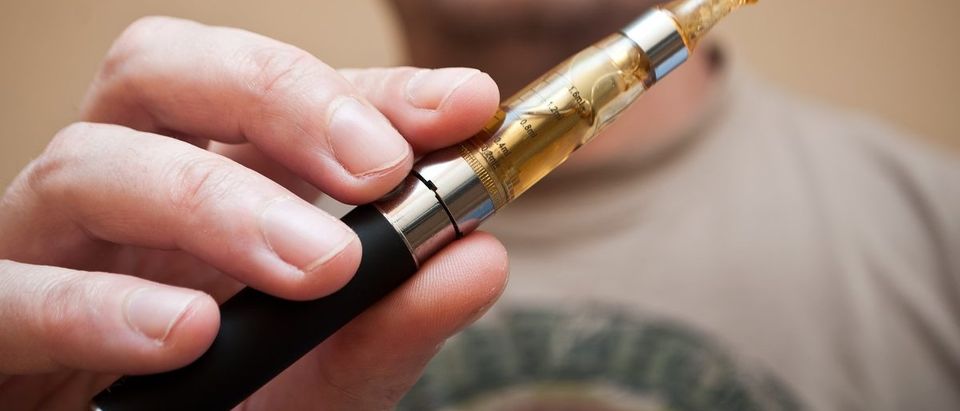 Adults Falsely Link Nicotine To Cancer | man with e-cigarette. (NeydtStock/Shutterstock)