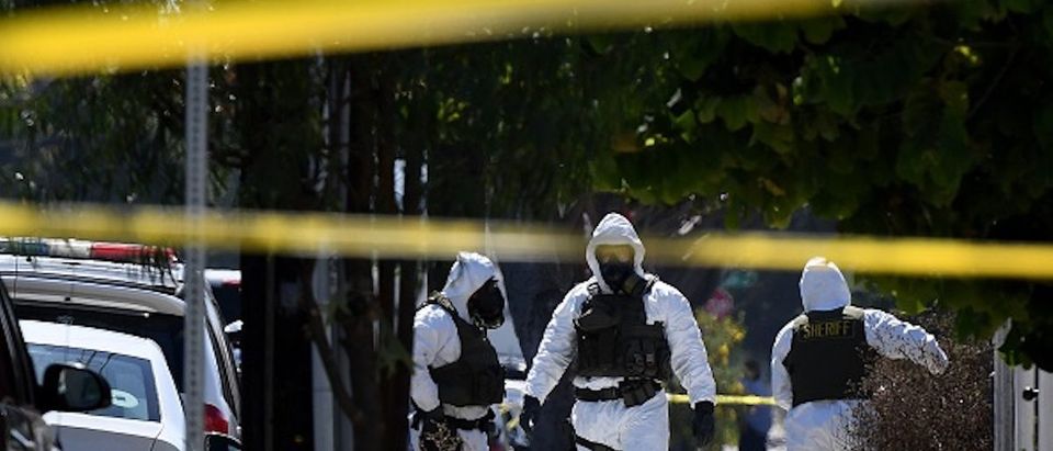 Members of the Los Angeles County Sheriff's Department bomb and hazmat squad, search a house where a large amount of military ordnance including artillery shells and grenades was found in Lawndale, California on September 29, 2017. Up to 100 local residents were evacuated to a nearby school, during the 14 hour operation to remove the ordnance from the residential property and one person was arrested in the raid. / AFP PHOTO / Mark RALSTON (Photo credit should read MARK RALSTON/AFP/Getty Images)