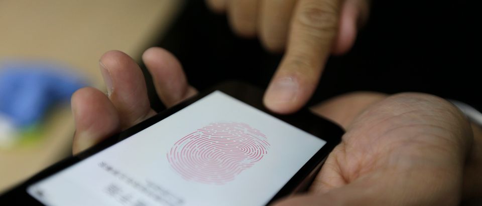 A journalist tests the the new iPhone 5S Touch ID fingerprint recognition feature in Beijing
