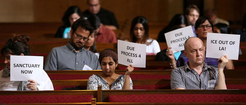 Immigrant supporters protest during the Los Angeles City Council ad hoc committee on immigration meeting to discuss the city's response to threats by the Trump administration to cut funding from Los Angeles