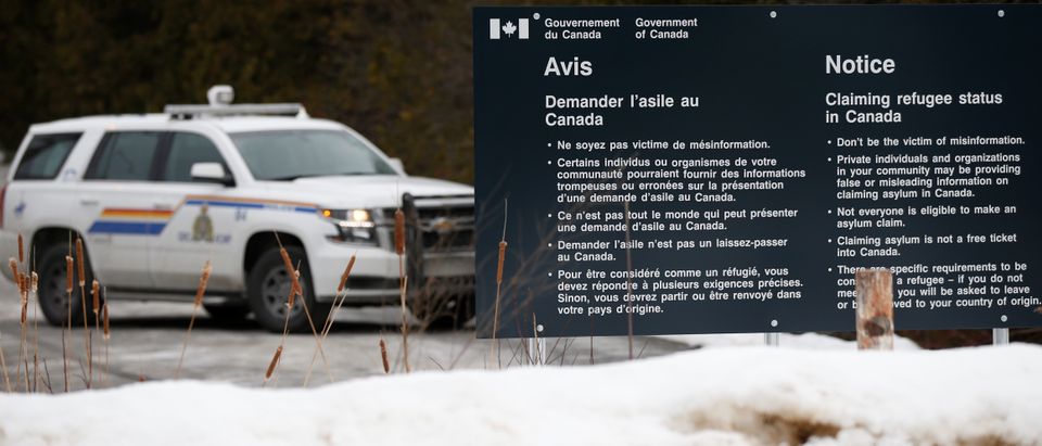 A Royal Canadian Mounted Police (RCMP) vehicle is seen near a sign at the US-Canada border in Lacolle, Quebec, Canada, February 14, 2018. REUTERS/Chris Wattie