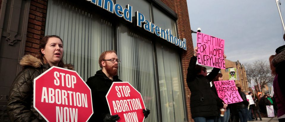 Anti-abortion activists (L) rally next to supporters of Planned Parenthood outside a Planned Parenthood clinic in Detroit, Michigan, U.S. February 11, 2017. REUTERS/Rebecca Cook