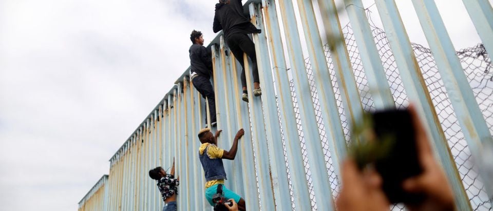 Members of a caravan of migrants from Central America climb up the border fence between Mexico and the U.S., as a part of a demonstration prior to preparations for an asylum request in the U.S., in Tijuana