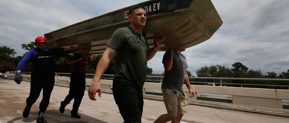People carry a rescue boat across a bridge to evacuate people from the rising waters of Buffalo Bayou following Hurricane Harvey in a neighborhood west of Houston, August 30, 2017. REUTERS/Carlo Allegri
