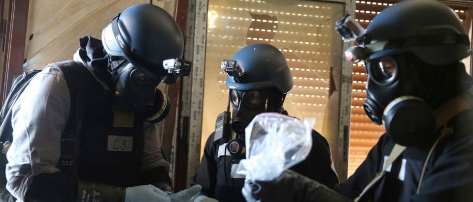 A U.N. chemical weapons expert, wearing a gas mask, holds a plastic bag containing samples from one of the sites of an alleged chemical weapons attack in the Ain Tarma neighbourhood of Damascus August 29, 2013. A team of U.N. experts left their Damascus hotel for a third day of on-site investigations into apparent chemical weapons attacks on the outskirts of the capital. Activists and doctors in rebel-held areas said the six-car U.N. convoy was scheduled to visit the scene of strikes in the eastern Ghouta suburbs. REUTERS/Mohamed Abdullah | Chemical Weapons Attacks Common In Syria
