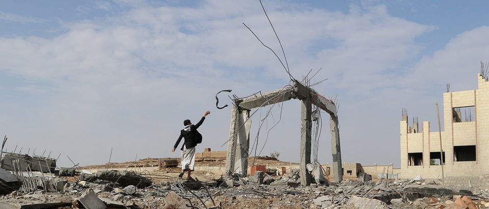 Man is seen at the site of an airstrike that destroyed the Community College in Saada