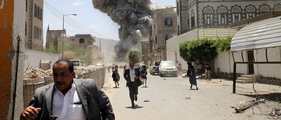 FILE PHOTO: People flee as smoke billows after air strikes hit the house of Yemen's former President Ali Abdullah Saleh in Sanaa