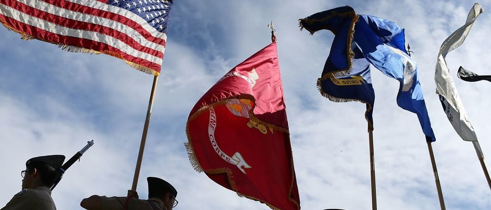 MIAMI BEACH, FL - NOVEMBER 11: Members of the G. Holmes Braddock Senior High School NJROTC color guard carry their flags during a Veterans day ceremony on November 11, 2015 in Miami Beach, Florida. Originally established as Armistice Day in 1919, the holiday was renamed Veterans Day in 1954 by President Dwight Eisenhower, and honors those who have served in the U.S. military. (Photo by Joe Raedle/Getty Images)