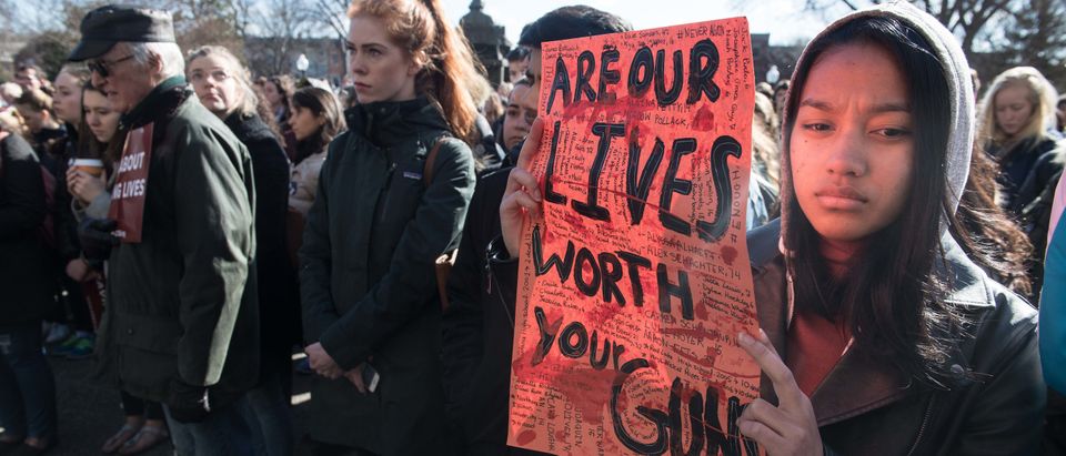 TOPSHOT - A student holds a sign at Georgetown University in Washington, DC, on March 14, 2018 during a national walkout to protest gun violence, one month after the school shooting in Parkland, Florida, in which 17 people were killed. / AFP PHOTO / NICHOLAS KAMM (Photo credit should read NICHOLAS KAMM/AFP/Getty Images)