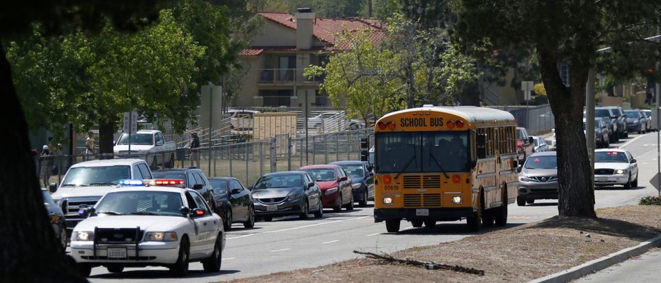 Police cars escort students in a bus after a shooting at North Park Elementary School, to be reunited with their parents in San Bernardino, California, U.S. April 10, 2017. REUTERS/Mario Anzuoni