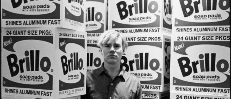 American pop artist Andy Warhol (1928 - 1987) stands amid his towering Brillo box sculptures in the Stable Gallery (33 East 74th Street), New York, New York, April 21, 1964. (Photo by Fred W. McDarrah/Getty Images) | Museum Auctioning Off Warhol Paintings