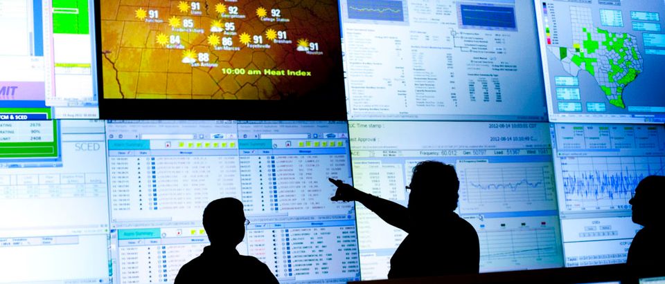 Reliability Coordinators Wes Watkins and Kim Engram and Steven Andrews monitor the state power grid during a tour of the Electric Reliability Council of Texas (ERCOT) command center in Taylor