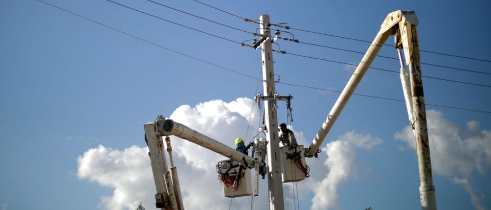 Workers repair part of the electrical grid following damages caused by Hurricane Maria in Jayuya, Puerto Rico