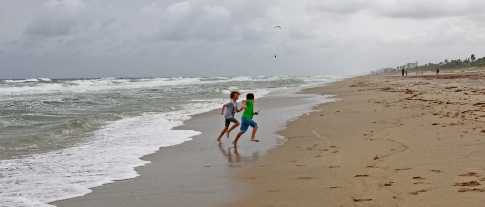 Abby Cowan and her brother Nate, visiting from Denver, Colorado, run on the beach as winds from Hurricane Sandy begin to affect weather in Delray Beach