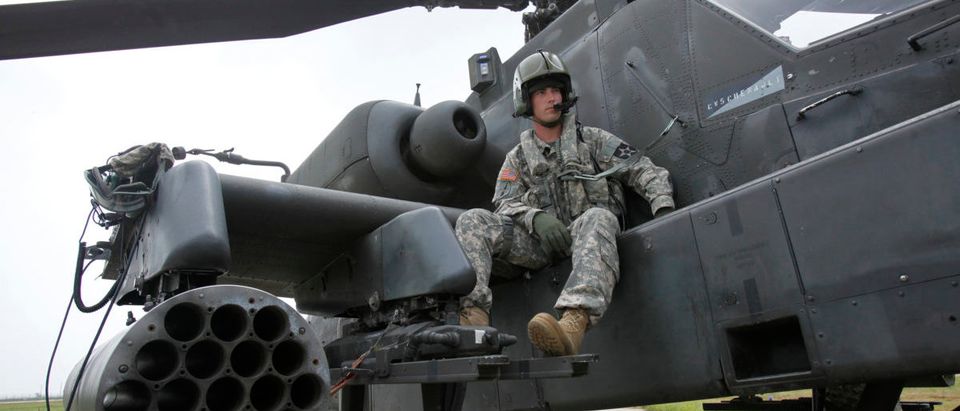 U.S. soldier Adam Elkins, Chief Warrant Officer of 4th Aviation Attack Battalion 2nd Combat Aviation Brigade, sits on an AH-64D Apache attack helicopter as he waits for a live-fire drill at a U.S. air base in Gunsan, about 270 km (168 miles) south of Seoul, July 21, 2009. REUTERS/Jo Yong-Hak