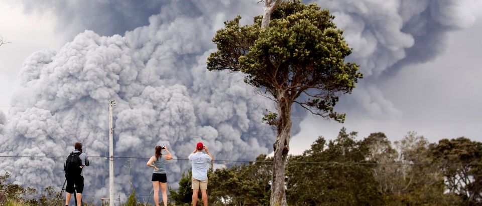 People watch as ash erupts from the Halemaumau crater near the community of Volcano during ongoing eruptions of the Kilauea Volcano in Hawaii, May 15, 2018. REUTERS/Terray Sylvester