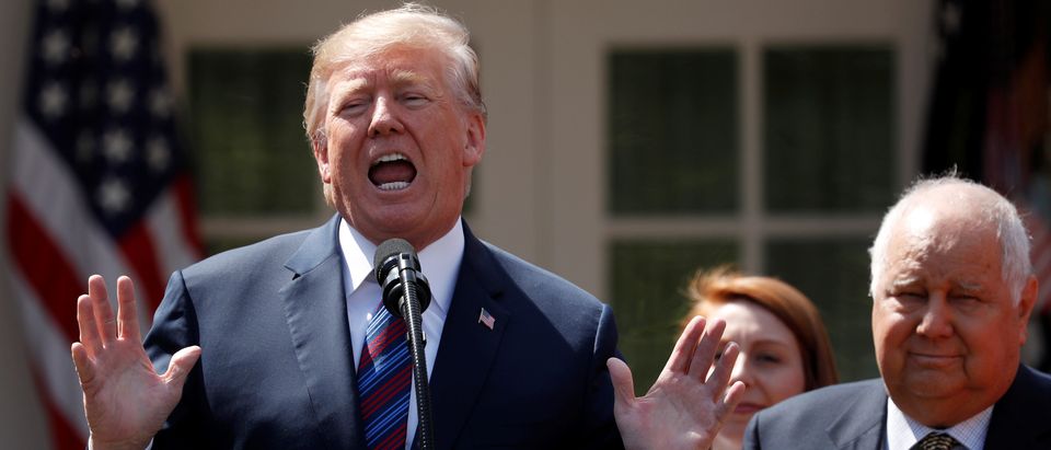 U.S. President Donald Trump gives remarks on tax cuts for American workers as Richard Kerzetski of Universal Plumbing, North Las Vegas, Nevada, listens during an event in the White House Rose Garden in Washington, U.S., April 12, 2018. REUTERS/Kevin Lamarque/File Photo - RC1E3CD3EA20