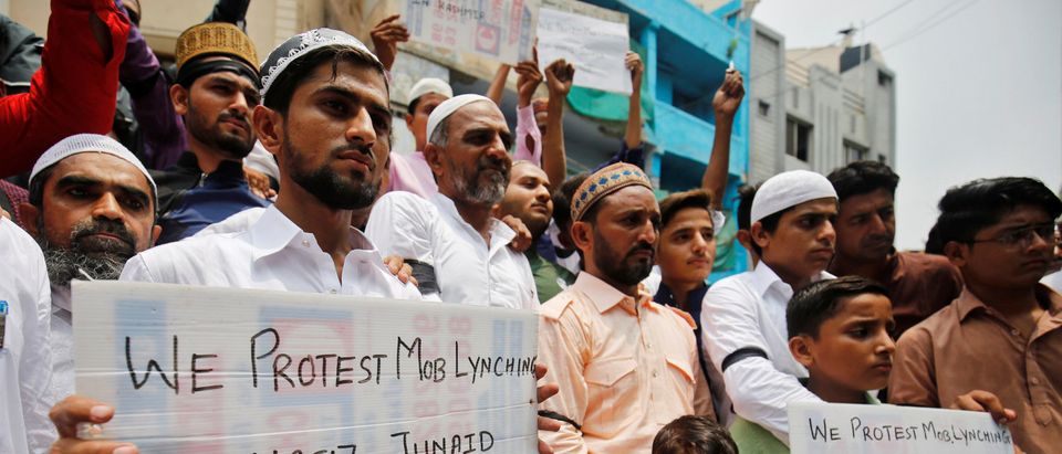 Muslims hold banners as they protest against the recent cases of mob lynching of Muslims who were accused of possessing beef, after offering Eid al-Fitr prayers in Ahmedabad
