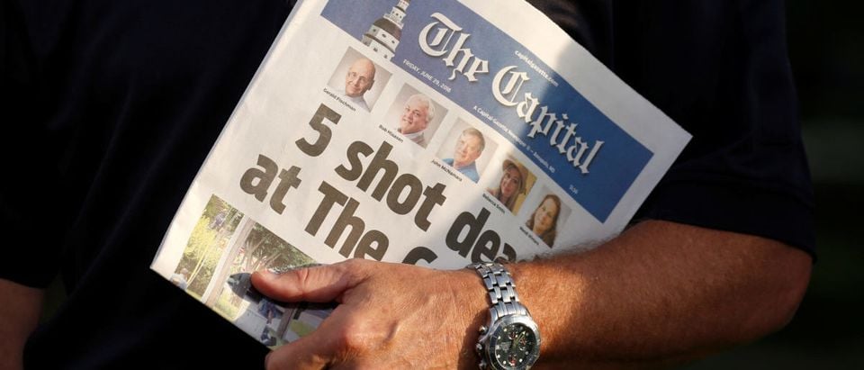 Steve Schuh, the County Executive of Anne Arundel County, Maryland, holds a copy of the Capital Gazette as he is interviewed the day after a gunman killed five people and injured several others at the newspaper's offices, in Annapolis, Maryland, U.S., June 29, 2018. REUTERS/Joshua Roberts