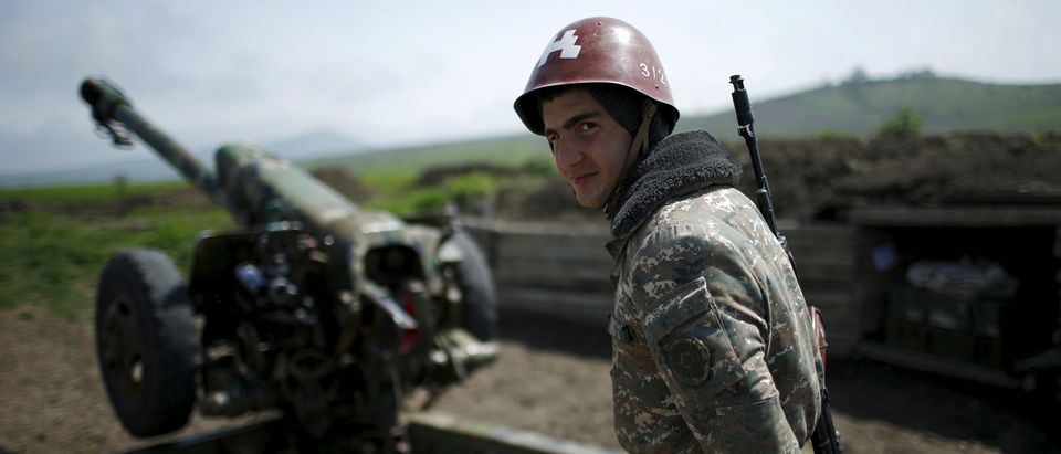 An ethnic Armenian soldier stands next to a cannon at the artillery positions near Nagorno-Karabakh's town of Martuni
