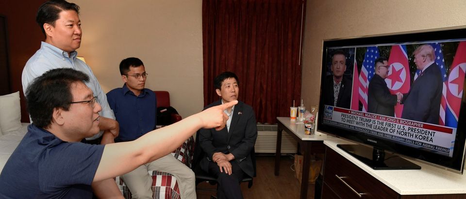 North Korean defectors Park Sang Hak and Justin Kim watch replays of President Donald Trump's summit meeting in Singapore with North Korea's Kim Jung Un on television, at a motel in Leesburg