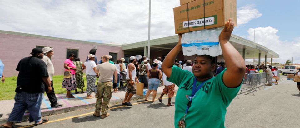 A resident stacks the water and food she received at an aid distribution center on her head in the aftermath of Hurricane Maria in Frederiksted, St. Croix, U.S. Virgin Islands September 29, 2017. REUTERS/Jonathan Drake
