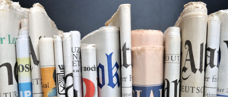 News - Folded newspapers in front of black wall. qvist/Shutterstock