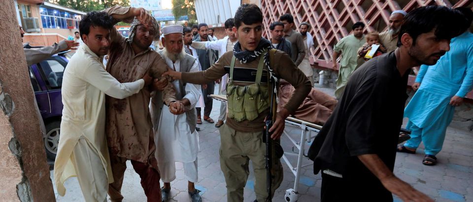 Men carry an injured man in a hospital after a suicide attack in Jalalabad