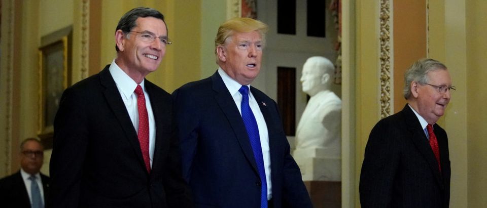 U.S. President Trump walks with Senator Barrasso and Senate Majority Leader McConnell in the U.S. Capitol for a meeting with Senate Republicans in Washington