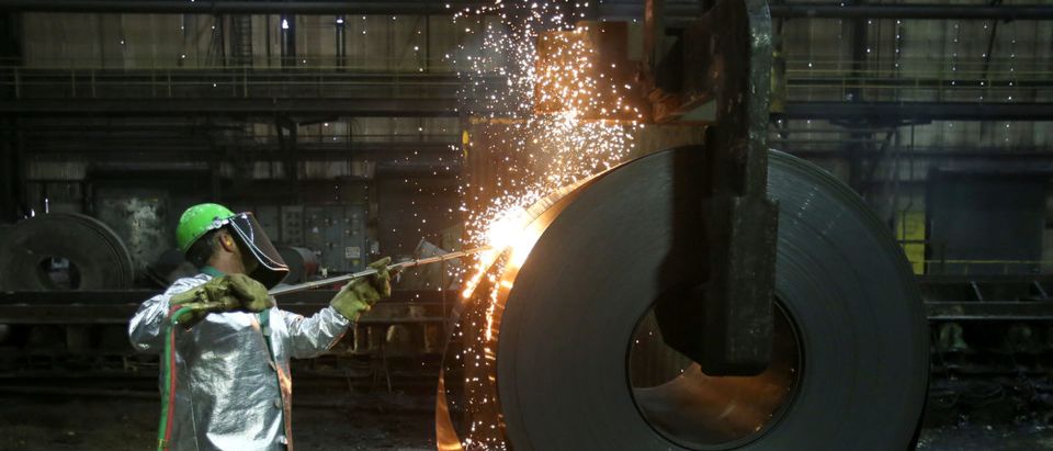 A worker cuts a piece from a steel coil at the Novolipetsk Steel PAO steel mill in Farrell