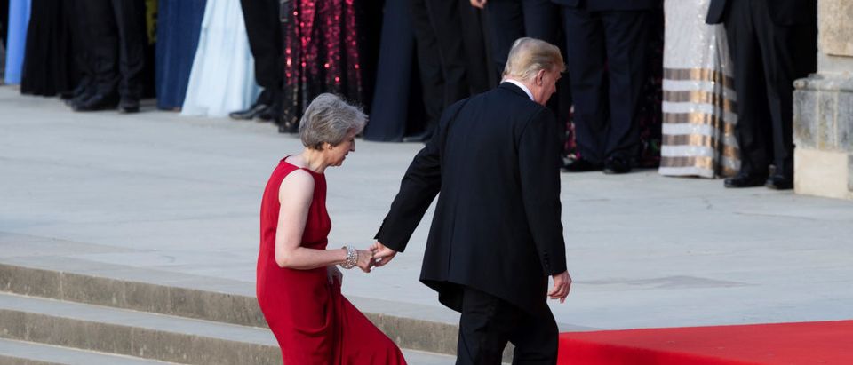 U.S. President Donald Trump leads British Prime Minister Theresa May by the hand as they climb the steps to the entrance of Blenheim Palace, where they are attending a dinner with other specially invited guests and business leaders, near Oxford, Britain, July 12, 2018. Will Oliver/Pool via REUTERS