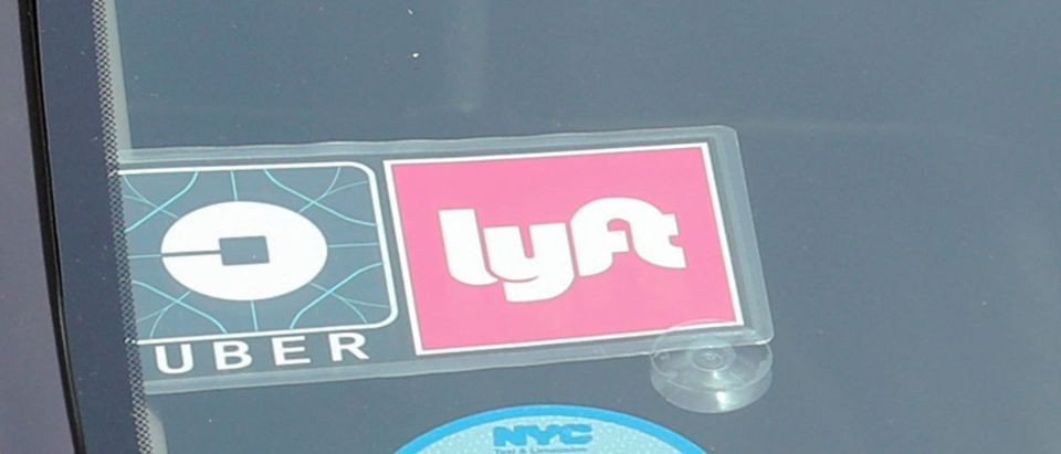 Uber and Lyft logos are seen on a vehicle in Manhattan