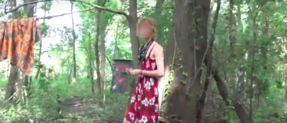 A man is camping in a swamp and wearing a red dress to protest a pipeline. (Photo: TheDCNF)