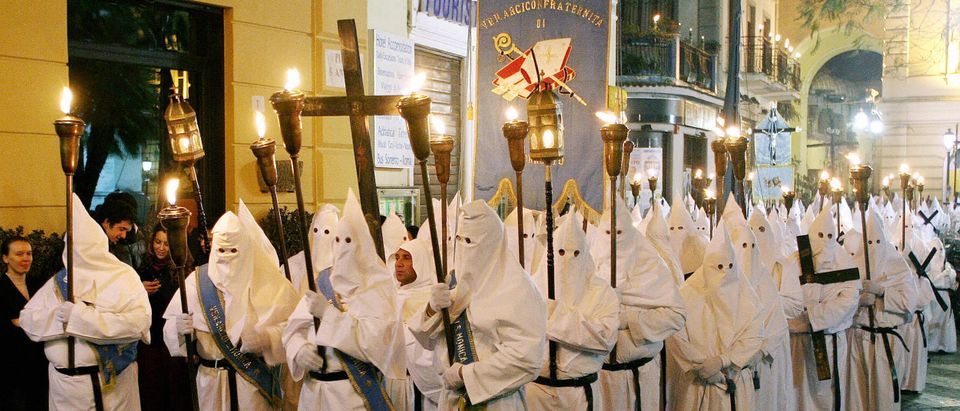 People wearing white robes and hoods rem