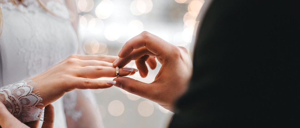 Man Puts Wedding Ring On Bride's Finger -- ShutterStock KirylV