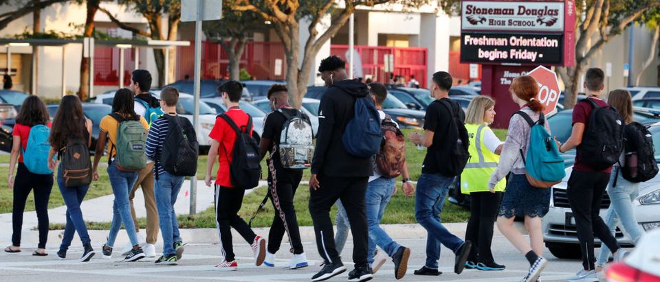 Students cross a street to enter for the first day of classes at Marjory Stoneman Douglas High School in Parkland