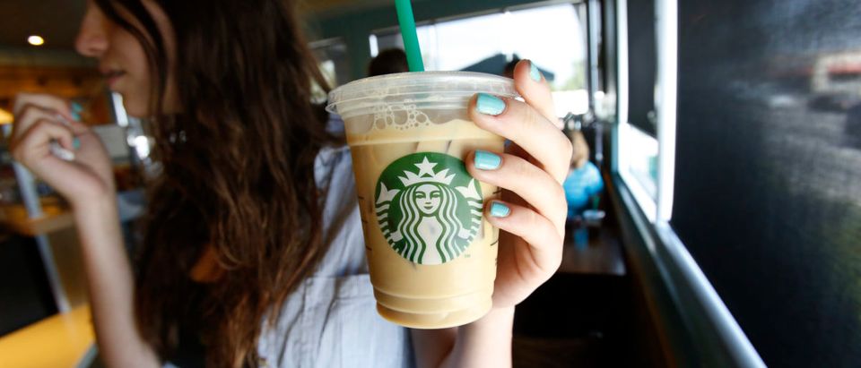 A patron holds an iced beverage at a Starbucks coffee store in Pasadena